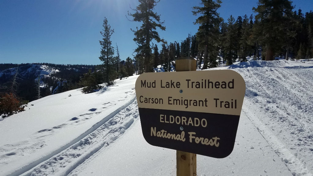 a sign that reads  mul lake trail  on a snowy slope