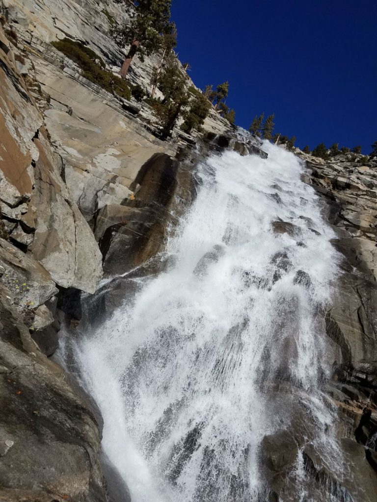 a waterfall is flowing down a rocky mountain