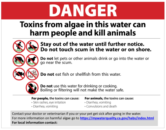 a sign warning about toxins from algae in this water can harm people and kill animals