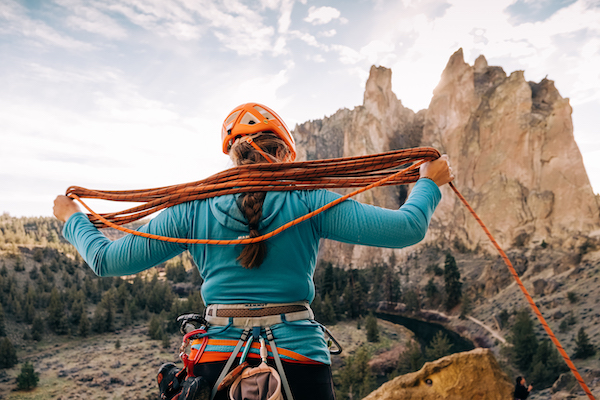Redmond, OR , USA - December , 02, 2021: @tabsrathbone coils an Alpine Sender 8.7 with the jagged rock pinnacles of Smith Rock state park in the background.