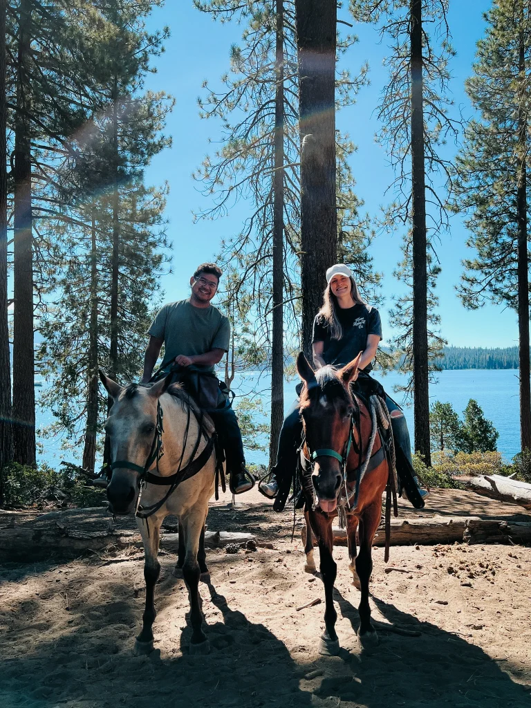couple horseback riding lake
