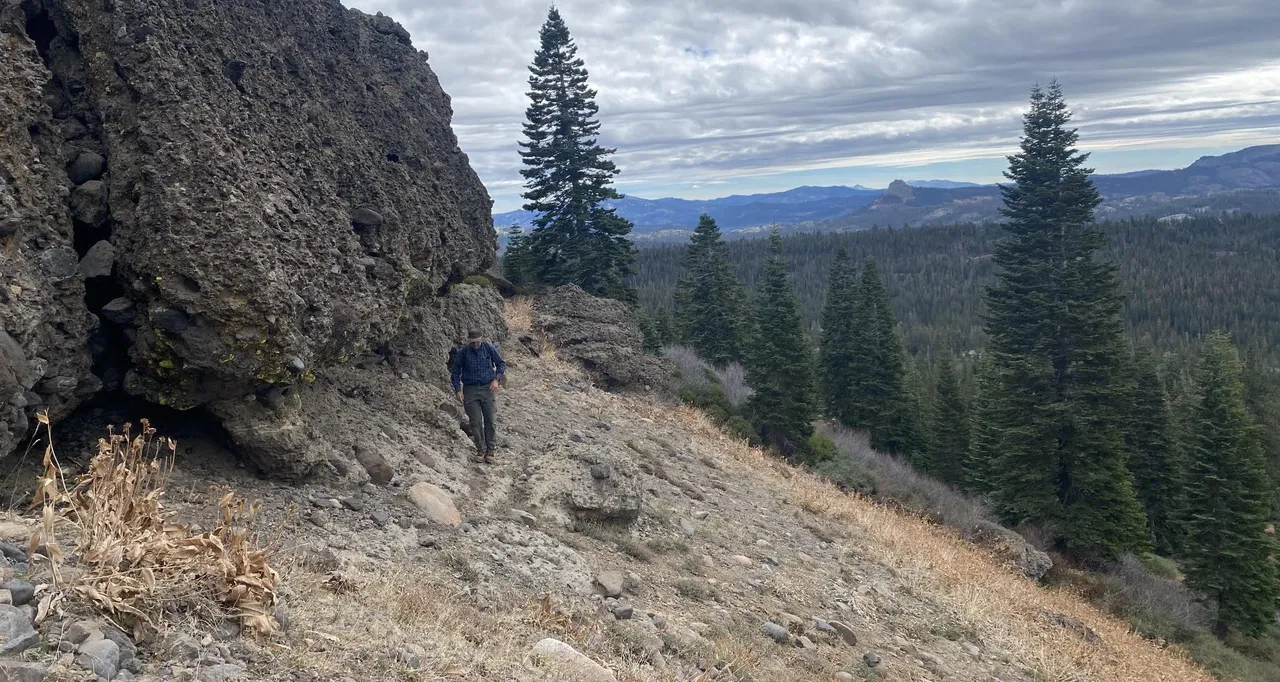 Truckee Trails Project Engineer Larry Lehman scouting the missing link section with Devil's Peak in the background